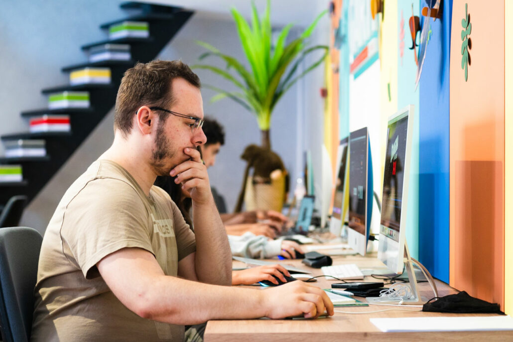 Jeune étudiant en pleine réflexion devant son ordinateur.
